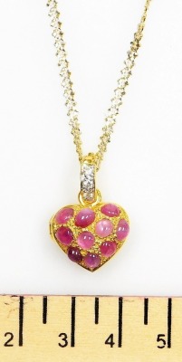 A heart shaped cabachon ruby set pendant locket, set with ten cabachon rubies of 3.8mm average, to a tiny diamond set suspension loop to a bi-colour precious metal chain, 38cm lng, 12.2g all in. - 2