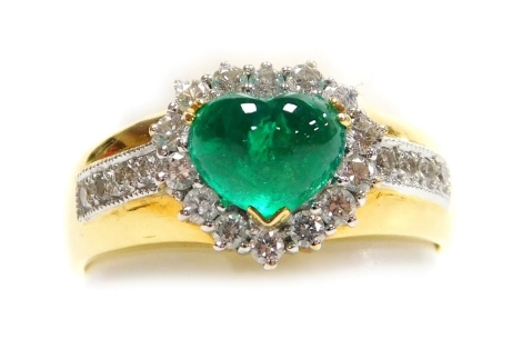 An emerald and diamond set dress ring, a central heart shaped cabachon emerald, 7mm x 5.5mm, surrounded by tiny diamonds with four tiny diamonds to each shoulder, set in precious yellow metal, size N, 5.2g all in.