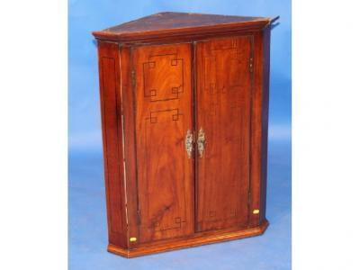 A George III flamed mahogany hanging corner cupboard