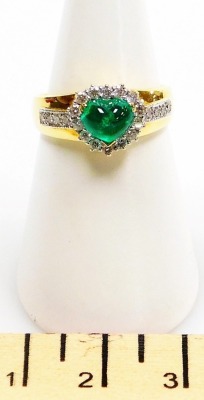 An emerald and diamond set dress ring, a central heart shaped cabachon emerald, 7mm x 5.5mm, surrounded by tiny diamonds with four tiny diamonds to each shoulder, set in precious yellow metal, size N, 5.2g all in. - 2