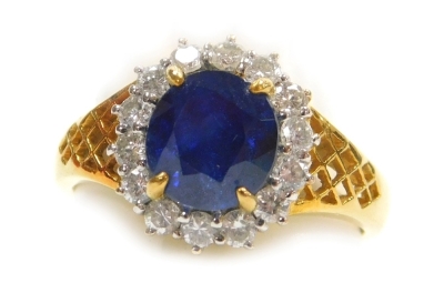 A sapphire and diamond cluster dress ring, the central stone of 6.6mm diameter surrounded by fourteen tiny diamonds, all in precious yellow metal, size N, 5.6g all in.
