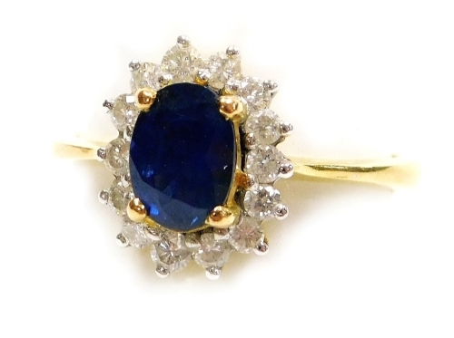 A sapphire and diamond set dress ring, the central faceted oval sapphire of 6.2mm x 5mm, surrounded by fourteen tiny diamonds, set in yellow precious metal, size L, 3.1g all in.