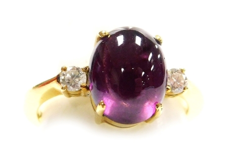 A cabachon ruby and diamond set dress ring, the central stone of 8.3mm x 7.5mm, high standing with a tiny diamonds set each side, to precious metal setting, size I½, 3.8g all in.