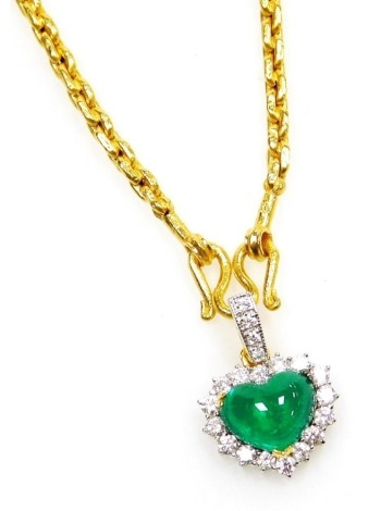 A heart shaped emerald and diamond pendant on chain, the cabachon emerald of 8.7mm x 6.7mm surrounded by sixteen tiny diamonds to a diamond set suspension loop on a medium weight chain, 34cm long, all in precious yellow metal, 6.3g all in.