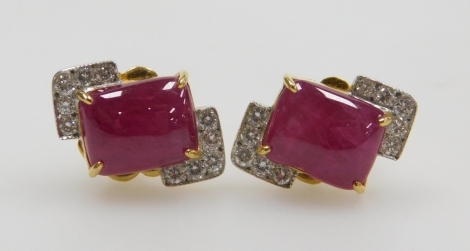 A pair of cushion cabachon ruby and diamond earrings, the central rectangular ruby of 8.7mm x 7mm edged by two diamond set corners, each of five tiny diamonds, 1.7mm x 7.8mm each approx, post and butterfly backs, set in precious yellow metal, 5.5g all in.