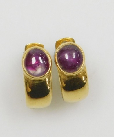 A pair of cabachon ruby clip and post earrings, the rutile included cabachons of 6.3mm diameter approx channel set in yellow precious metal, 1.5cm x 0.6cm each, 6.1g all in.