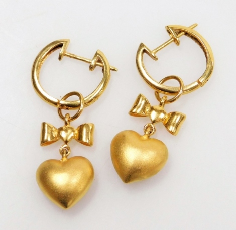 A pair of hoop and drop earrings, a pierced heart below a bow to a clip and post hoop, 3.6cm x 1.1cm average, all in precious yellow metal, 8.4g all in.