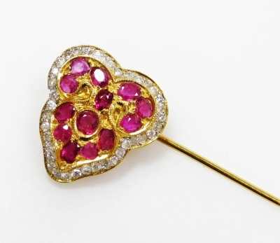 A ruby and diamond set stick pin, the heart shaped head set with thirteen various size small rubies, surrounded by tiny diamonds, 1.8cm x 1.7cm, all in precious yellow metal, 4g all in.