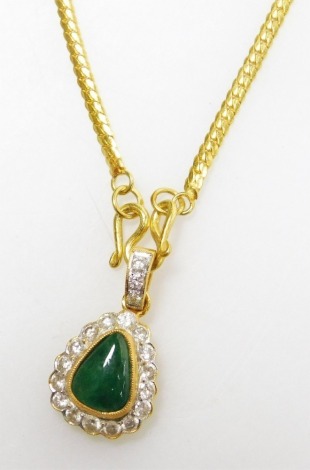 A tear drop jade and diamond set pendant on chain, the central cabachon stone of 8.8mm x 6.8mm widest point, surrounded by tiny diamonds to diamond set suspension loop, to serpentine chain, all in yellow precious metal, 40cm long, 9.9g all in.