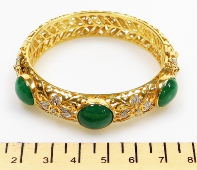 An ornate jade and diamond set hinged bangle, three cabachon jade stones of 11.3mm x 9.1mm approx each, on an ornate carved hollow bangle with tiny diamond set accents to the front, internal diameter 5.2cm, external diameter 6.5cm, 1.2cm wide, 51.4g all i - 2