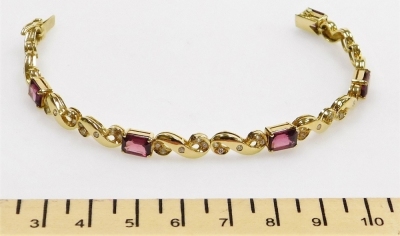 A tourmaline and diamond set articulated bracelet, five rectangular faceted stones of 7.3mm x 5mm average, linked by S scrolls set with tiny diamonds, push clip clasp, 17cm long approx, 14.8g all in, in precious yellow metal. - 2