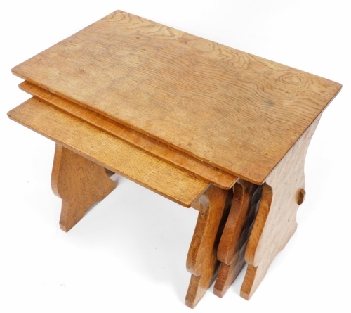 A nest of three Thomas Whittaker Gnomeman oak tables, each of rectangular form, on trestle type supports, the gnome carved to the support of the largest table, the largest 43cm high, the top 63.5cm x 37cm.