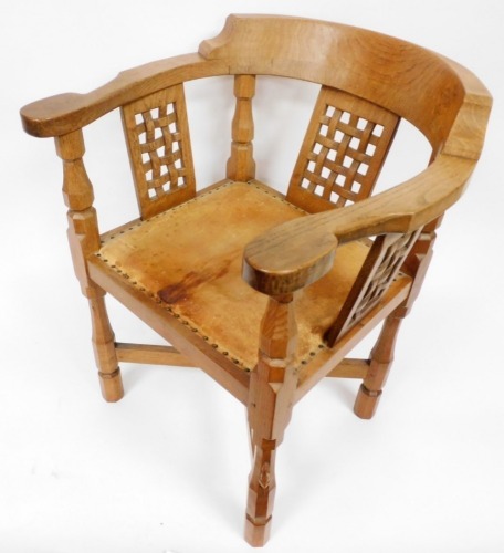 A Robert Thompson Mouseman oak monk's chair, with a curved back and shaped arms, over three lattice work panels, with a studded leather seat, on four octagonal legs with carved mouse to front, united with an X shaped stretcher, model number CH010, 79.5cm