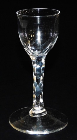 A late 18thC Georgian wine glass, the plain bowl raised on a faceted stem and conical foot, 13.5cm high.