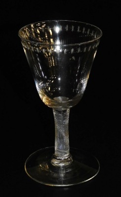 A late Georgian wine glass, the bowl engraved with a repeating star motif, raised on a spiral fluted plain stem, above a conical foot, 12.5cm high.