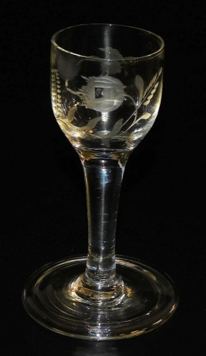 A late 18thC Georgian wine glass, the bowl engraved with bird and flower, alluding to Jacobite sympathies, raised on a straight stem and conical folding foot, 12cm high.