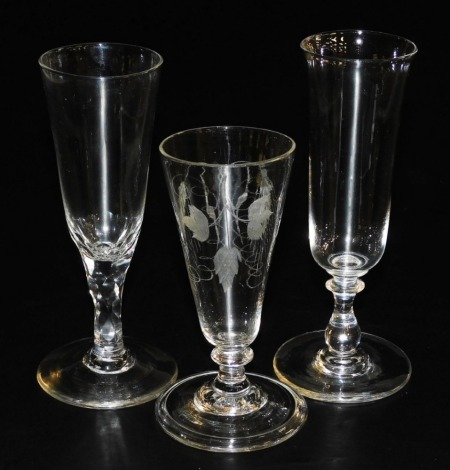 A late 18thC Georgian ale glass, engraved with hops and barley, raised on a single knop stem and conical folded foot, 13cm high, later ale glass raised on a faceted stem and one further glass. (3)