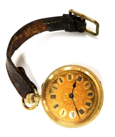 An early 20thC lady's fob watch, stamped 18k, open faced, keyless wind, the circular dial bearing Roman numerals, the case with floral and foliate engraving, vacant shield reserve, 27.7g all in.