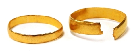 A 22ct gold wedding band, cut, and a further 22ct gold wedding band, misshapen, 3.4g.
