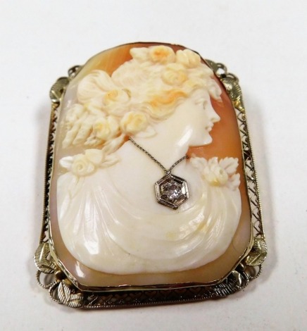 An early 20thC American shell cameo brooch, bust portrait of a lady, wearing a real diamond set necklace, in a yellow metal frame, with pin and loop suspension, stamped 14K, 5cm high, 3.5cm wide, 17.5g.