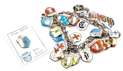 An early 20thC German silver and enamel charm bracelet, set with shields of various cities, towns, and regions, etc., 38.7g.