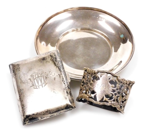 A group of small silver, comprising a George V dish, of plain form with raised rim, Chester 1911, 11.5cm diameter, a George V cigarette case, initialled, Birmingham 1929, 8cm high, and a Victorian napkin ring, initialled, with pierced decoration, hallmark