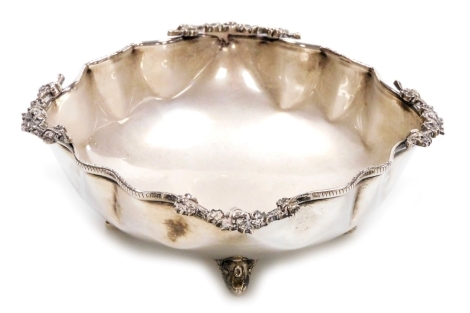 A white metal dish, of square form, with a shaped rim with applied cast flowers to each corner, raised on four scroll cast feet, marked 900, 3.09oz, 11cm wide.