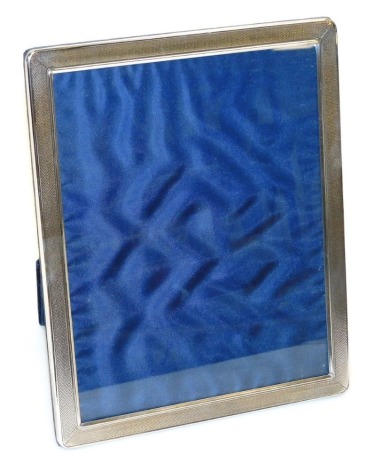 An Elizabeth II silver mounted photograph frame, of rectangular form with engine turned decoration and strut support, Sheffield 1994, 28.5cm x 23.5cm.