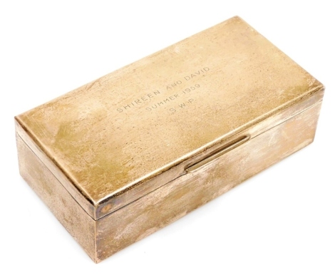 An Elizabeth II silver cigarette box, of plain rectangular form, the hinged lid presentation engraved 'Shireen and David, Summer 1959 SWP,' treen interior, Birmingham 1958, 18cm wide.