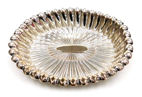 A Continental white metal dish, of oval form with a shaped and pierced border, part fluted, unmarked, 1.47oz, 11cm wide.