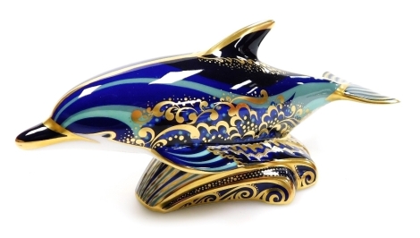 A Royal Crown Derby porcelain Bottlenose Dolphin paperweight, gold stopper and red printed marks, 19cm wide, boxed.