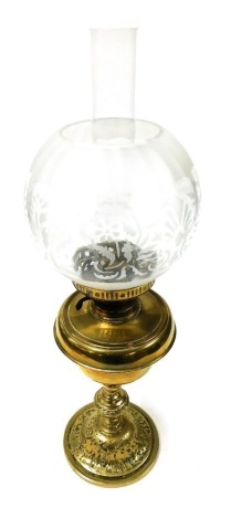 An early 20thC brass oil lamp, with chimney and etched clear glass shade, 63cm high.