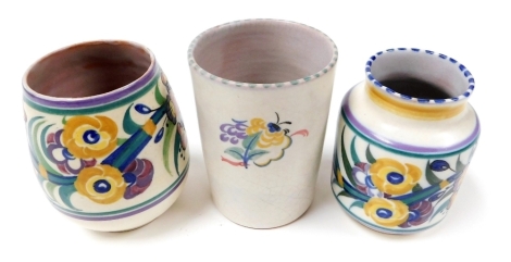 A Carter Stabler Adams Poole pottery vase traditionally decorated with flowers, 10cm high, another similar, 9.5cm high, and a beaker painted with flowers, 10cm high.