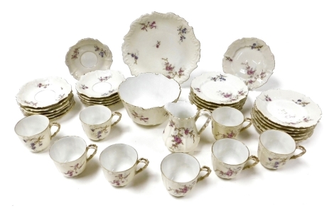 An early 20thC Limoges porcelain tea service, decorated with floral sprays, gilt heightened against a cream ground, comprising cream jug and sugar bowl, bread plate, eight teacups, twelve saucers, and tea plates.