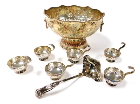 A silver plated semi fluted punch bowl, together with six cups, embossed with flowers and leaves, and a plated King's pattern ladle.