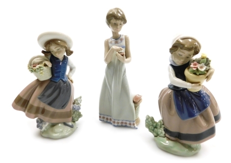 A Lladro porcelain figure of a girl with a basket of flowers, figure of a girl with a vase of flowers, and a further girl. (3, AF)