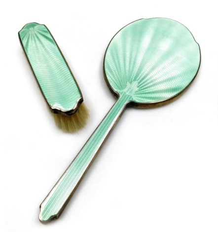 A George V silver backed and pale green guilloche enamel hand mirror and clothes brush, Birmingham 1921.