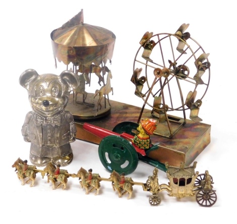 A Cavalier silver plated Mickey Mouse money box, Walt Disney Productions, 15cm high, together with a Crescent scale model of the state coach, drawn by eight horses and four riders, and a tin carousel, with musical movement, 26cm wide. (3)