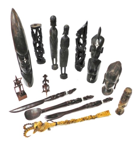 A group of African tribal figural carvings, busts, salad servers, and a shoe horn. (a quantity)