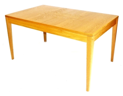 A light oak draw leaf dining table, raised on tapering square legs, 77cm high, 145cm wide, 195cm extended, 90cm deep.