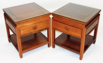 A pair of Chinese hardwood bedside chests, the tops with glass protectors, over a single frieze drawer, raised on square legs united by an under tier, 52cm high, 45.5cm wide, 45.5cm deep.