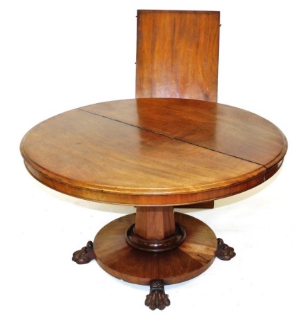 An early Victorian mahogany pedestal dining table, with one additional leaf, the circular top raised on an octagonal out swept column and circular base, raised on four lion's paw feet, 69cm high, 120cm wide, 171cm extended.