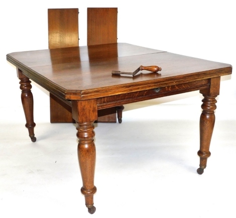 A Victorian oak extending dining table, with two half additional leaves, raised on turned legs, capped on castors, with winder, 74cm high, 135cm wide, 200cm extended, 105.5cm deep.