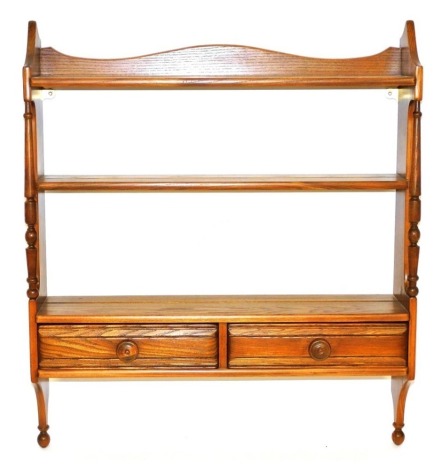 An Ercol elm wall hanging plate rack, the three shelves over a pair of frieze drawers, design 1102, 81.5cm high, 69cm wide,19cm deep.