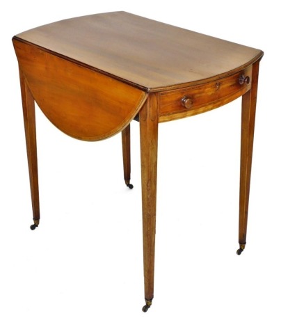 A George III mahogany and boxwood line inlaid Pembroke table, with one side and one dummy drawer, raised on tapering square legs, brass capped on castors, 73cm high, 76cm wide, 47.5cm deep, 91.5cm extended.