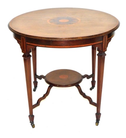 An Edwardian mahogany and satinwood circular occasional table, raised on tapering square legs, united a circular undertier, on spade feet, brass capped on castors, 74cm high, 82cm wide.