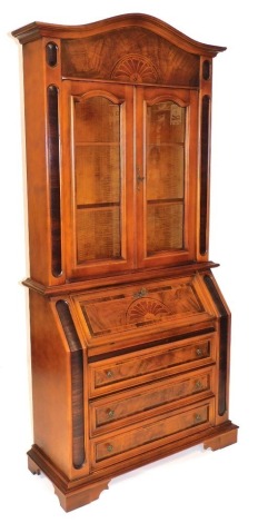 A Continental cherry, rosewood and inlaid bureau bookcase, the domed top with a demi lune floral motif, over a pair of glazed doors enclosing two shelves, the bureau with fall flap opening reveal three drawers and recesses, over three long drawers, raised