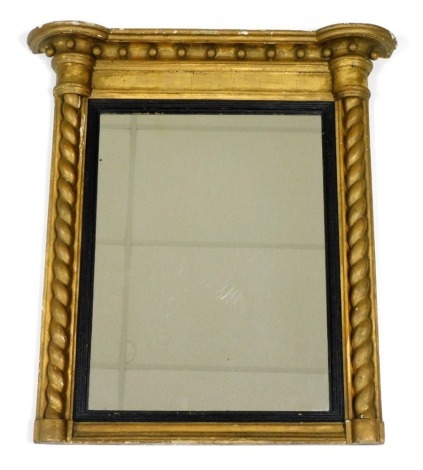 A 19thC giltwood overmantel mirror, the outswept pediment over rectangular glass within an ebonised slip, flanked by spiral twist columns, 76cm high, 69cm wide.