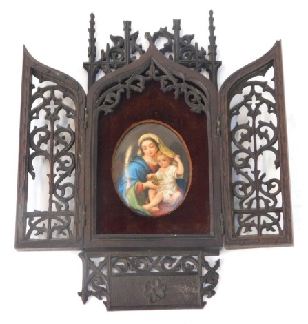 A late 19thC cased religious icon, the carved and pierced mahogany fret work case opening to reveal an oval painted porcelain portrait of mother and child carrying grapes, possibly Berlin, the portrait 8cm x 6cm, the case 26cm x 10.5cm.