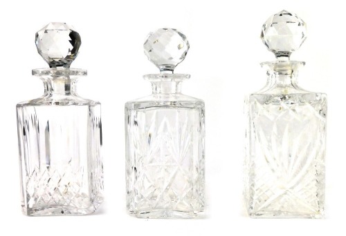 Three crystal decanters, each of varying cross hatched design, with stoppers, 25cm high.